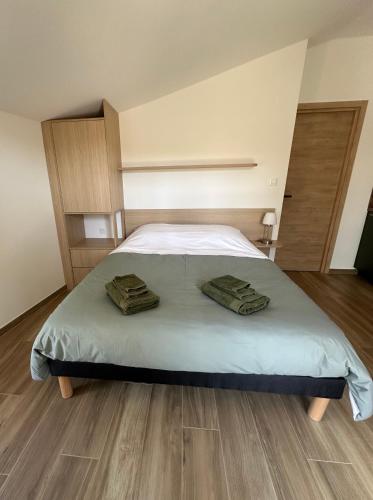 a bedroom with a bed with two towels on it at Appartement PICHOLINE in Saint-Sorlin-en-Bugey
