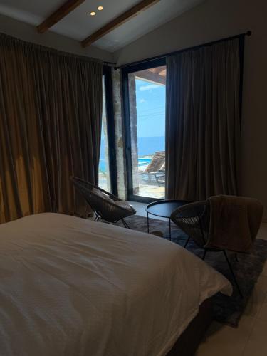a bedroom with a bed and a view of the beach at Terracotta Villa in Himare