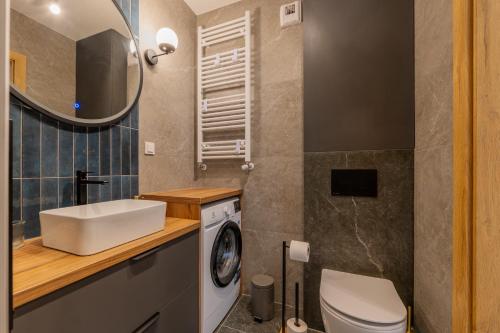 a bathroom with a sink and a washing machine at Navy Blue Apartment - SPA - Basen - Parking in Dziwnów