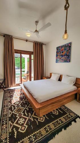 a bedroom with a large bed and a rug at Oxygen Beachfront Hotel, Paje in Paje