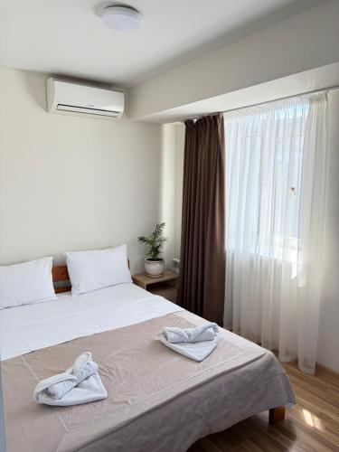 a bedroom with two towels on a bed with a window at Smart House Home in Kyiv