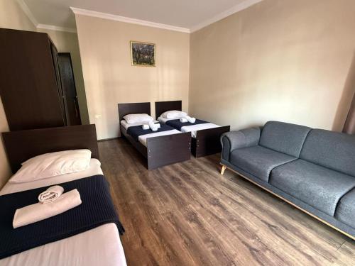 a hotel room with two beds and a couch at Hotel Sunny Coast in Kobuleti