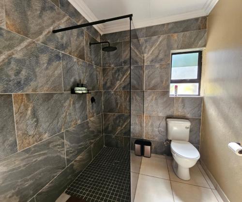 a bathroom with a shower and a toilet in it at Oblique Boutique House in Centurion