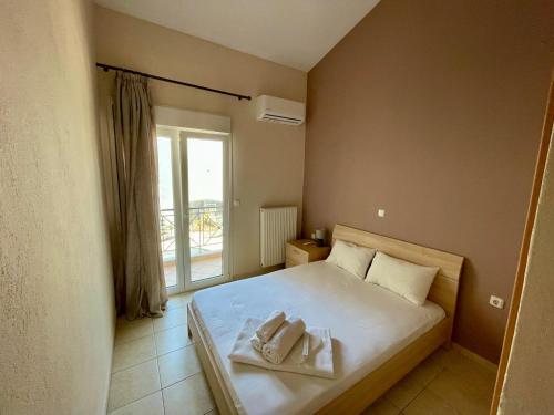 a bedroom with a bed with two towels on it at Feel free in Paleo Tsifliki