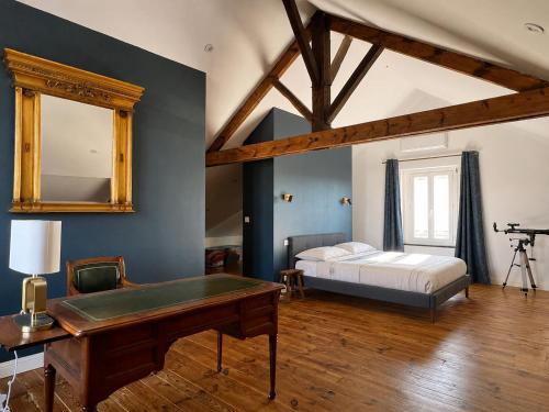 a bedroom with a bed and a table and a mirror at villa des roses in Bergerac