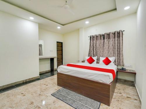 a bedroom with a large bed with red pillows at HOTEL O M J HEIGHTS in Garhā