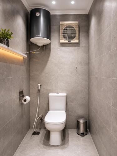 a bathroom with a toilet and a fan at Aziz Egypt Hotel in Cairo