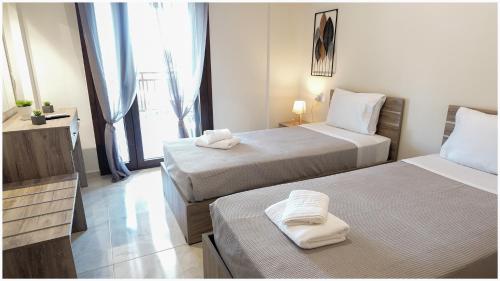a hotel room with two beds and a television at Buena Vista - San Mames in Agios Mamas