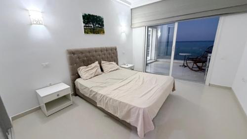 a bedroom with a bed and a view of the ocean at Le paradis 210 in Kelibia