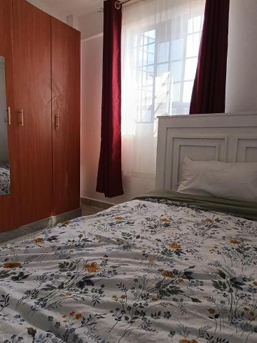 a bedroom with a bed with a floral comforter at BR Homes 2 Bedroom in Bungoma