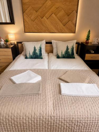 a bed with two towels and two pillows on it at Borovets Gardens Studio Raya in Borovets