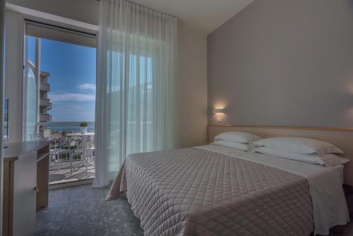 a bedroom with a bed with a view of the ocean at Hotel Constellation in Rimini
