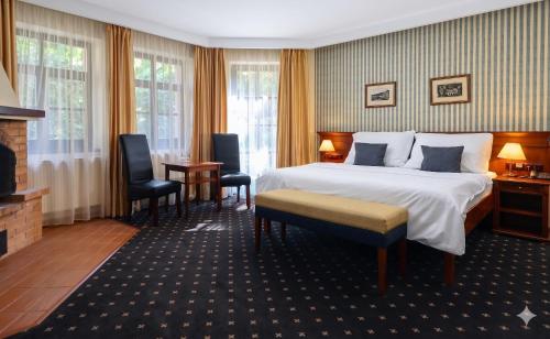 a hotel room with a bed and a fireplace at Wellness Golf Hotel Morris in Mariánské Lázně
