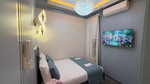 a bedroom with a bed and a tv on a wall at Santa Rio Taxim in Istanbul