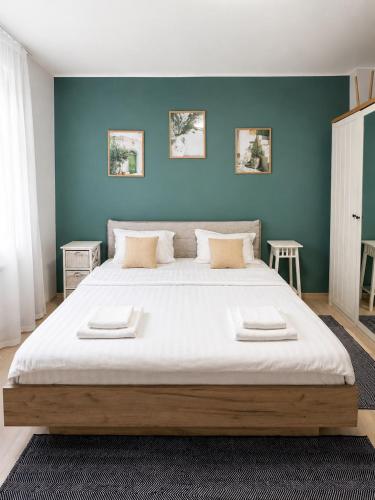 a bedroom with a large bed with blue walls at Casa Family in Eforie Sud