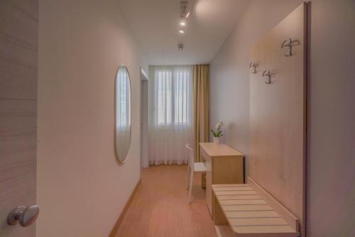 a white room with a desk and a mirror at Hotel Constellation in Rimini