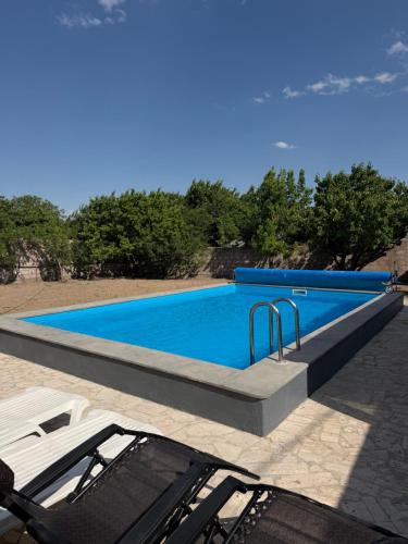 a swimming pool with two chairs sitting next to it at Blue Garden in Nor Hachyn