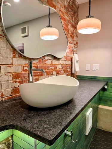 a bathroom with a large white sink and a mirror at Gamble Mill in Bellefonte