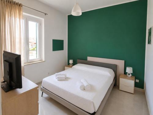 ein Schlafzimmer mit Bett und Flachbildfernseher in der Unterkunft Etnera in Trecastagni