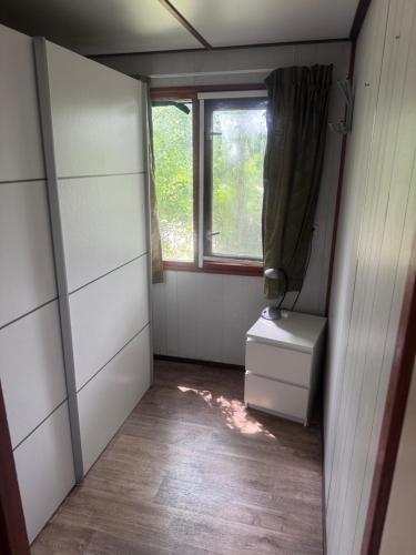 a small room with a window and a dresser at Chalet Feanzicht in Earnewâld