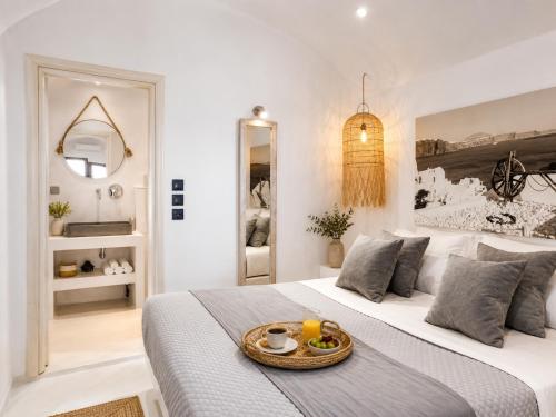 a white bedroom with a bed with a tray on it at Cliff Caldera Modern Suites -Volcano, Sunset & Caldera View in Fira