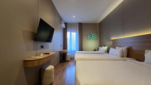 a hotel room with two beds and a television at Hotel Bankir Khiva in Khiva