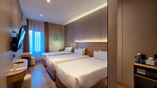 a hotel room with two beds and a television at Hotel Bankir Khiva in Khiva
