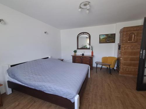 a bedroom with a bed and a dresser and a chair at U Podnóża Gór in Nowa Ruda