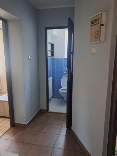 a bathroom with a toilet and a glass door at U Podnóża Gór in Nowa Ruda