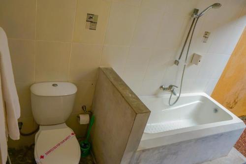 a bathroom with a toilet and a bath tub at Muthukirula Resort in Aluthgama
