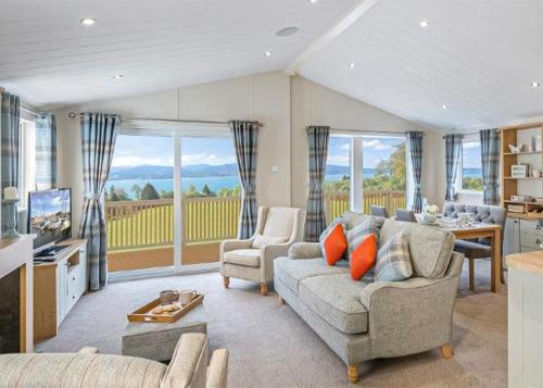 a living room with a couch and a table and some windows at Unity Beach in Brean