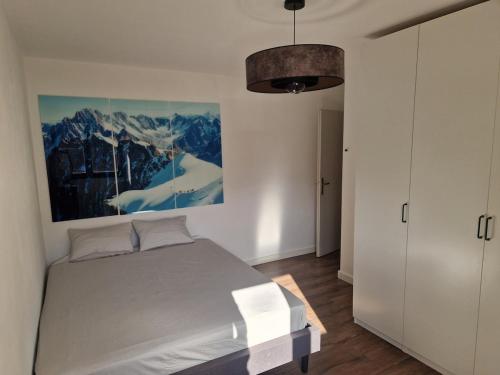 a bedroom with a bed and a painting on the wall at Appartement Pila - Faverges in Faverges