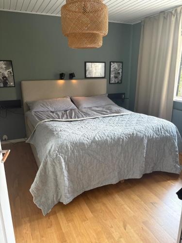 a bedroom with a bed with a white comforter at Enplansvilla med pool in Tyresö