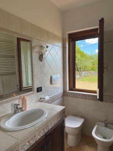 a bathroom with a sink and a toilet and a window at La Casa nel Bosco in Arezzo