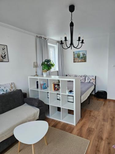 a living room with a couch and a white book shelf at Blick auf die Kirche in Wschowa