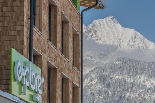 a sign on the side of a building with a mountain at Explorer Hotel Kitzbühel in Sankt Johann in Tirol