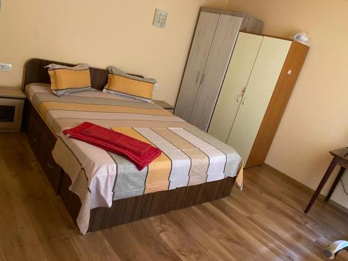 a small bedroom with a bed with a wooden floor at Casa Roxana in Constanţa