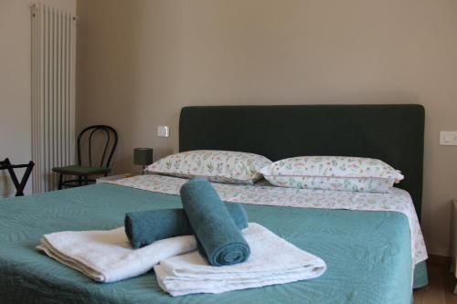 a green bed with towels and pillows on it at CASA K2 - Lago Maggiore in Castelveccana