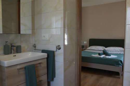 a bathroom with a sink and a bed at CASA K2 - Lago Maggiore in Castelveccana