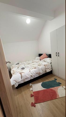 a bedroom with a bed and a rug on the floor at Apartman Jakovljević in Gornja Toplica