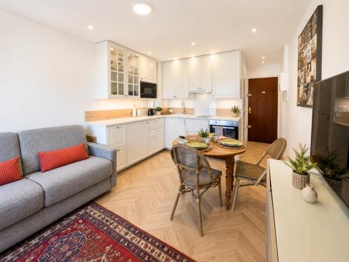 a kitchen and living room with a couch and a table at Méva in Courseulles-sur-Mer