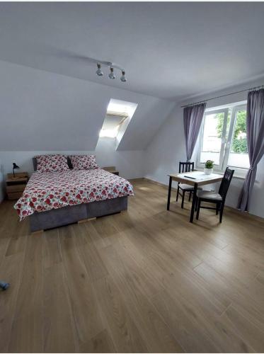 a bedroom with a bed and a table in it at Domki, pokoje, apartamenty Agata Kunowska in Ostrzyce