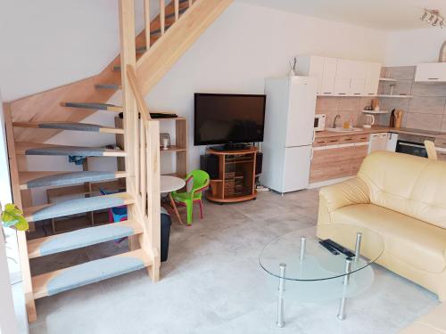 a living room with a spiral staircase and a couch at Łapacz Mazurskich Chwil in Orzysz