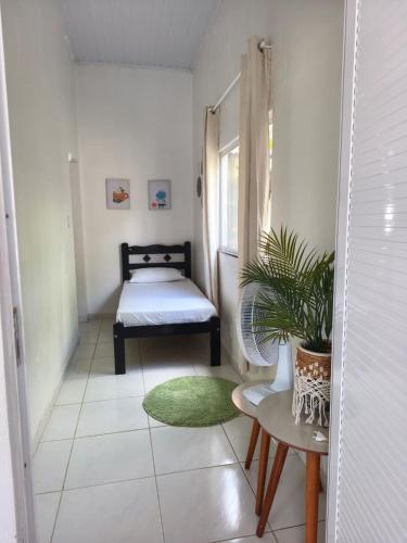a small room with a bed and a green rug at Summer House in Jijoca de Jericoacoara