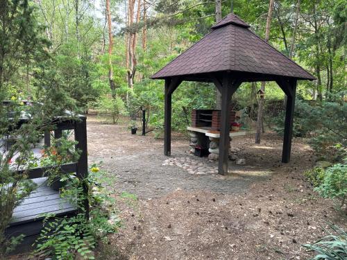 a gazebo with a bench in the woods at Leśna Chata Arciechów in Arciechow