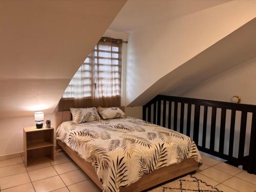 a bedroom with a bed and a window at Duplex cosy au cœur de Sinnamary, fleuve à pied- Samélé House in Sinnamary