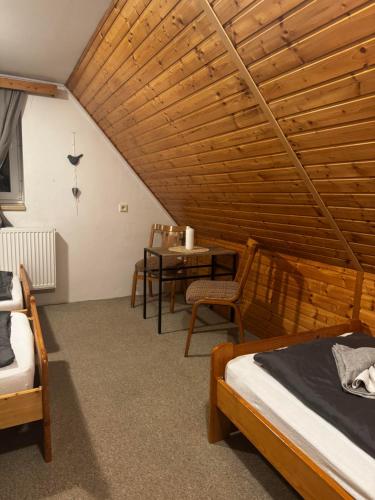 a attic room with two beds and a table at Pension MÍŠA in Velká Úpa