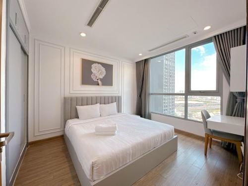 a bedroom with a bed and a desk and a window at The Fermin Premium Studios in Ho Chi Minh City