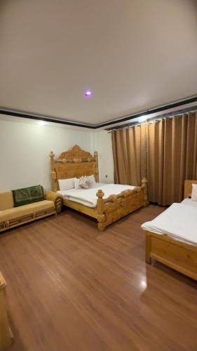 two beds in a room with wooden floors at Malam jabba Hotel reservation in Swat