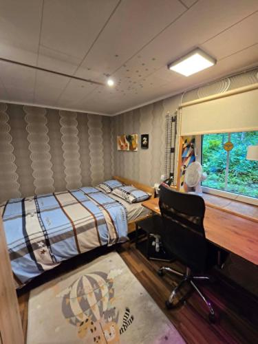 a bedroom with a bed and a desk with a computer at Unique and private summer apartment in Tartu